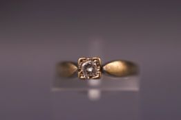 A yellow metal single stone ring set with a round brilliant cut diamond. Shank stamped DIA .10.