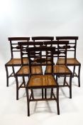 A set of six mahogany Recency style dining chairs with brass inlaid horizontal splat caned seats