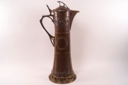 An Art nouveau style copper jug with brass finial, handle and pierced foot, 40.