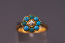 A yellow metal cluster ring set with eight turquoise and a central old cut diamond measuring 3.7mm.