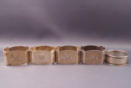 A set of four silver engine turned oblong napkin rings,
