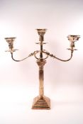 A silver candelabrum with three branches, each with detachable sconces above corinthian capitals,