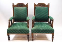 A pair of late Victorian armchairs with carved mahogany frames,