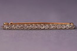An Edwardian yellow and white metal diamond bar brooch set with seventeen old brilliant cut