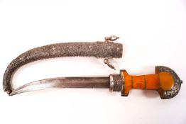 A Middle Eastern curved dagger in decorative white metal scabbard