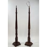 A pair of oak standard lamps, of turned baluster form on rounmd base with four feet,