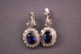 A white metal pair of synthetic sapphire and diamond drop earrings. Post and clip fittings.