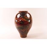 A terracotta art nouveau two handled vase painted with poppies indistinctly marked,