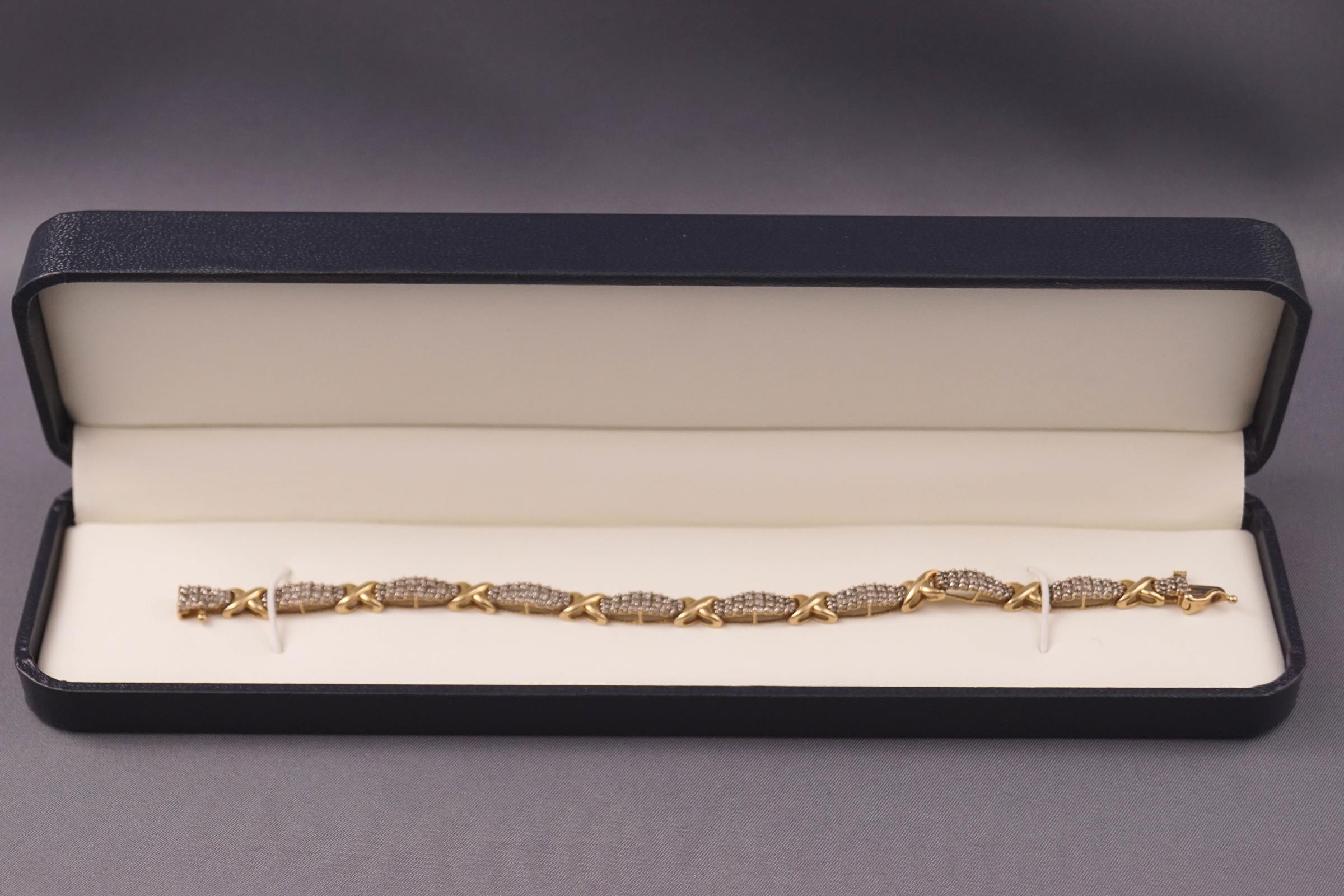 A yellow and white metal diamond bracelet set with round brilliant cut diamonds estimated to be 3.