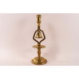 A brass candlestick with a bell above the drip pan on flared domed foot, 31.