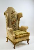 A Victorian walnut wing back armchair with tapestry style upholstery