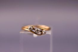 A yellow metal three stone diamond ring. Tests indicate 18ct gold. Size; H. Weight: 1.