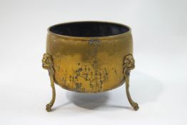 A brass coal scuttle with three lion mask and paw legs,
