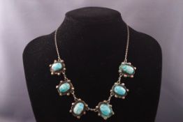 An Egyptian silver and faience scarab beetle necklace and a pair of matching clip earrings.