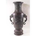 A late 19th/early 20th century Japanese bronze two handled vase, decorated with birds in relief,