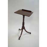 A Regency mahogany reading table on turned column and outswept legs,