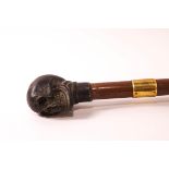 A walking stick with bronze skull's head knop and a gold collar,