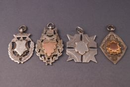 Four silver fob medallions with vacant cartouches including two with gold panels,