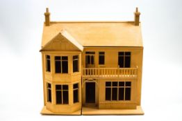 A dolls house in the form of a Victorian residence with bow front beside two storeys with a balcony,