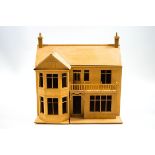 A dolls house in the form of a Victorian residence with bow front beside two storeys with a balcony,