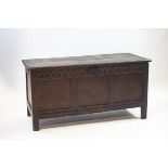 A 17th century oak coffer with triple panelled front and later carved frieze,