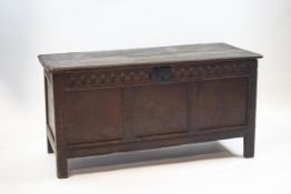 A 17th century oak coffer with triple panelled front and later carved frieze,