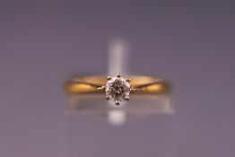A yellow and white metal single stone ring set with a round brilliant cut diamond measuring 4.00mm.