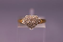 A yellow and white metal heart shape diamond cluster ring. Hallmarked 18ct gold. Size: K 1/2.
