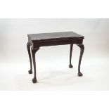 A George III style mahogany card table, the fold over top enclosing a brown baize surface,