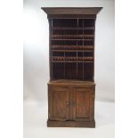 An 18th century French elm dresser, with hood top over four shelves and cupboard base,