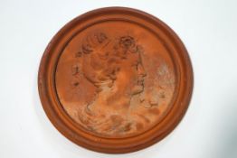 A terracotta roundel moulded with a ladies profile with ribbons in her hair,