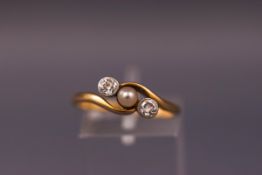 A yellow metal three stone diamond and pearl ring. Stamped 18ct. Size O 1/2. Weight: 2.