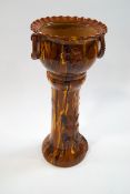A late Victorian slipware jardiniere on stand, the planter with ring handles and crimped rim,