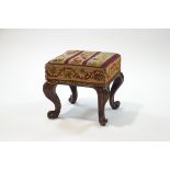 A Victorian square rosewood footstool with woolwork seat on carved cabriole legs,