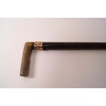 A Gentleman's walking cane with horn handle and gold coloured collar,