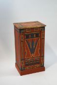 A painted pine pot cupboard decorated with Egyptian style motifs on a pink ground,