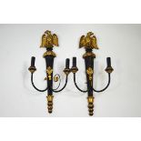 A pair of Regency style two branch wall lights each surmounted by a gilt eagle,