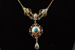 A yellow metal black opal centerpiece necklace having a fancy scroll design and set with cabochon