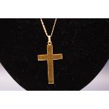 A yellow metal plain cross pendant suspended from a fancy linked chain, Cross stamped 750.