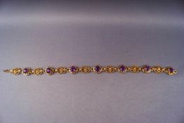 A yellow metal bracelet of abstract design set with seven round cut amethysts.