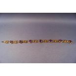 A yellow metal bracelet of abstract design set with seven round cut amethysts.