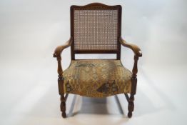 An early 20th century beech elbow chair with caned back