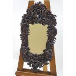 A decorative wall mirror in moulded frame, simulating carved mahogany,