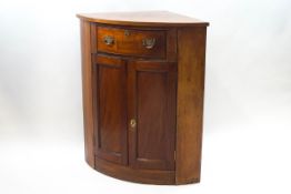 A mahogany standing corner cabinet, with one drawer above two panelled doors,