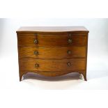 A George III mahogany serpentine chest of three drawers with a brushing slide,