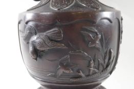 A late 19th/early 20th century Japanese bronze two handled vase, decorated with birds in relief,