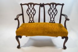 An Edwardian mahogany double sofa, the backs with Chippendale style splats, scroll arms,