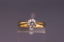 A yellow and white metal single stone ring. Set with a round brilliant cut diamond measuring 5.3mm.