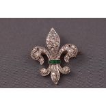 An 18ct and platinum emerald and diamond fleur de lys brooch.