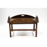 A mahogany butlers tray coffee table with four hinged sides on square tapering legs,